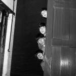 The Beatles peering out from behind a door. before the groups appearence at Sunday Night at the London Palladium, 13 October 1963