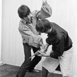 George Harrison and Ringo Starr engage stage mock combat at the rented home in Bel Air Los Angeles during a tour of the USA August 1964
